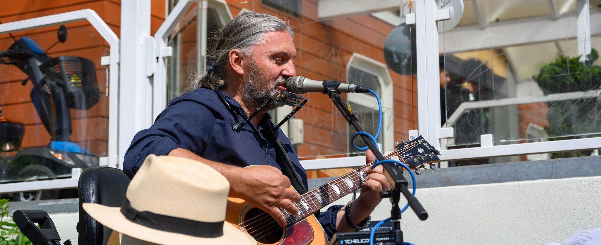 Musiker spielt akustische Gitarre und singt in ein Mikrofon bei einer Veranstaltung in Heilbad Heiligenstadt